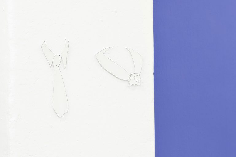 Detail of two collars on a white wall, in the right third of the image in the crop a purple wall. The right collar shows a shirt collar with tie, the left one a kind of blouse collar, which seems to end in the middle in a kind of knotted flower. Both collars cast a small shadow and are recognizable as slightly three-dimensional.